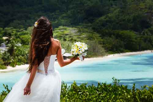 Bride overlooking bay and the beach