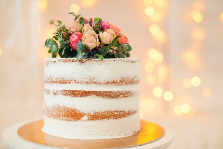 Wedding cake with light icing and real flowers on top