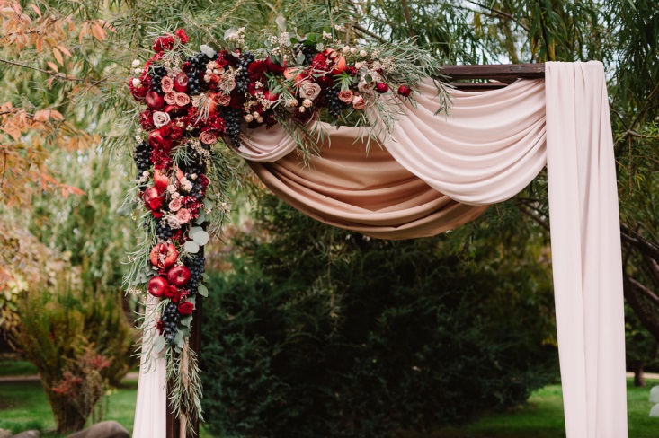 Arbor decorated with apples and pears for fall-inspired wedding