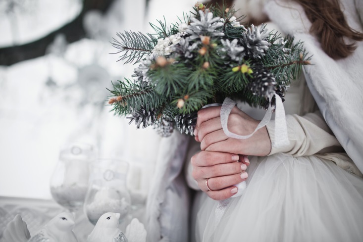 Bride's hands holding a winter-inspired bouquet