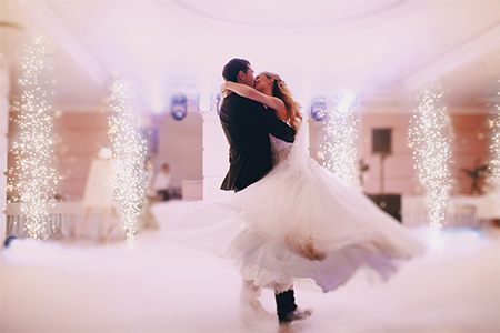 Groom spinning bride during their first wedding dance